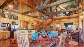 A rustic wooden cabin interior with a dining area, kitchen, and living space. - 3 Chicks Ranch, 2 Cabins, Pool, Hot Tub & Hill Country (New Braunfels)