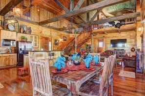 A rustic wooden cabin interior with a dining area, kitchen, and living space. - 3 Chicks Ranch, 2 Cabins, Pool, Hot Tub & Hill Country (New Braunfels)
