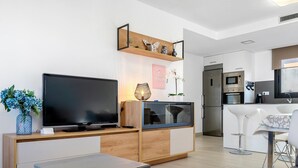 En moderne stue med et fladskærms-tv, et træskab og et lille bord.