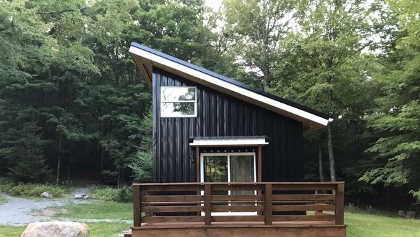 A cabin with a wooden deck and a window.