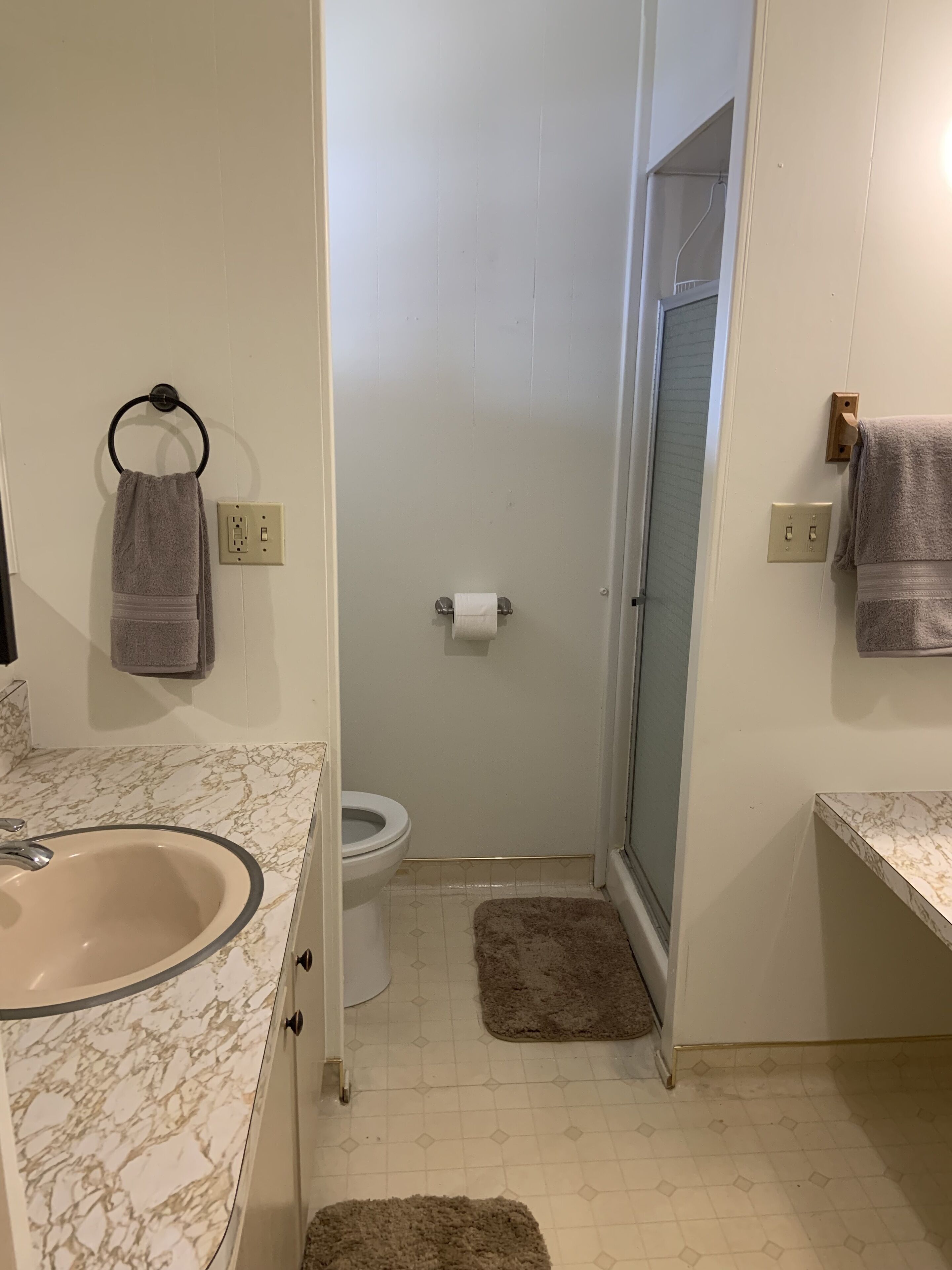 Un baño con lavamanos, inodoro y ducha de mármol.