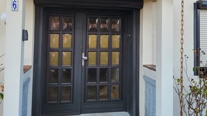 A house with a dark front door, a number '6' sign, and a small welcome mat. - Holiday Home 'Anker Perla' with Private Terrace and Wi-Fi (Grömitz)