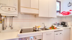 Een moderne keuken met witte kastjes, een inbouwoven, een spoelbak en een vaatwasser.
