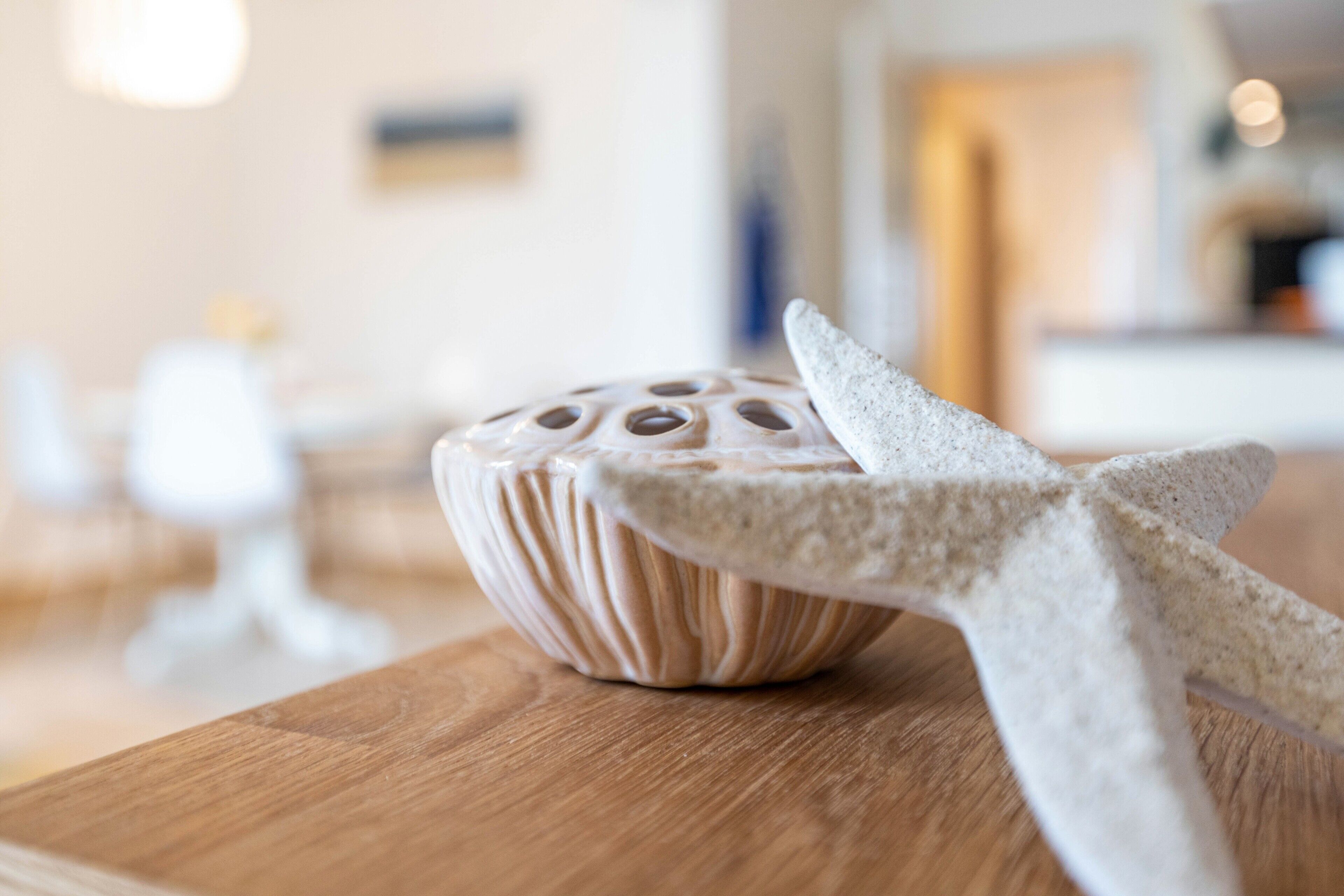 Uma mesa de madeira com um objeto decorativo e um tecido branco.