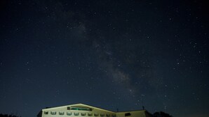 Um edifício com vários andares e janelas, sob um céu estrelado.