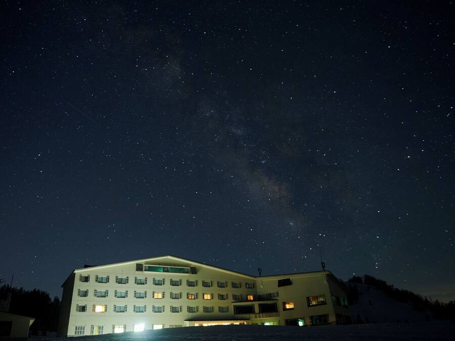 A building with multiple floors and windows, under a starry night sky.
