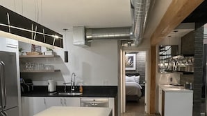 A modern kitchen with a central island, bar stools, and a dining area. - 3b/2b "Beadle Box" Architectural Loft w/ Doghouse + Golf (Mesa)