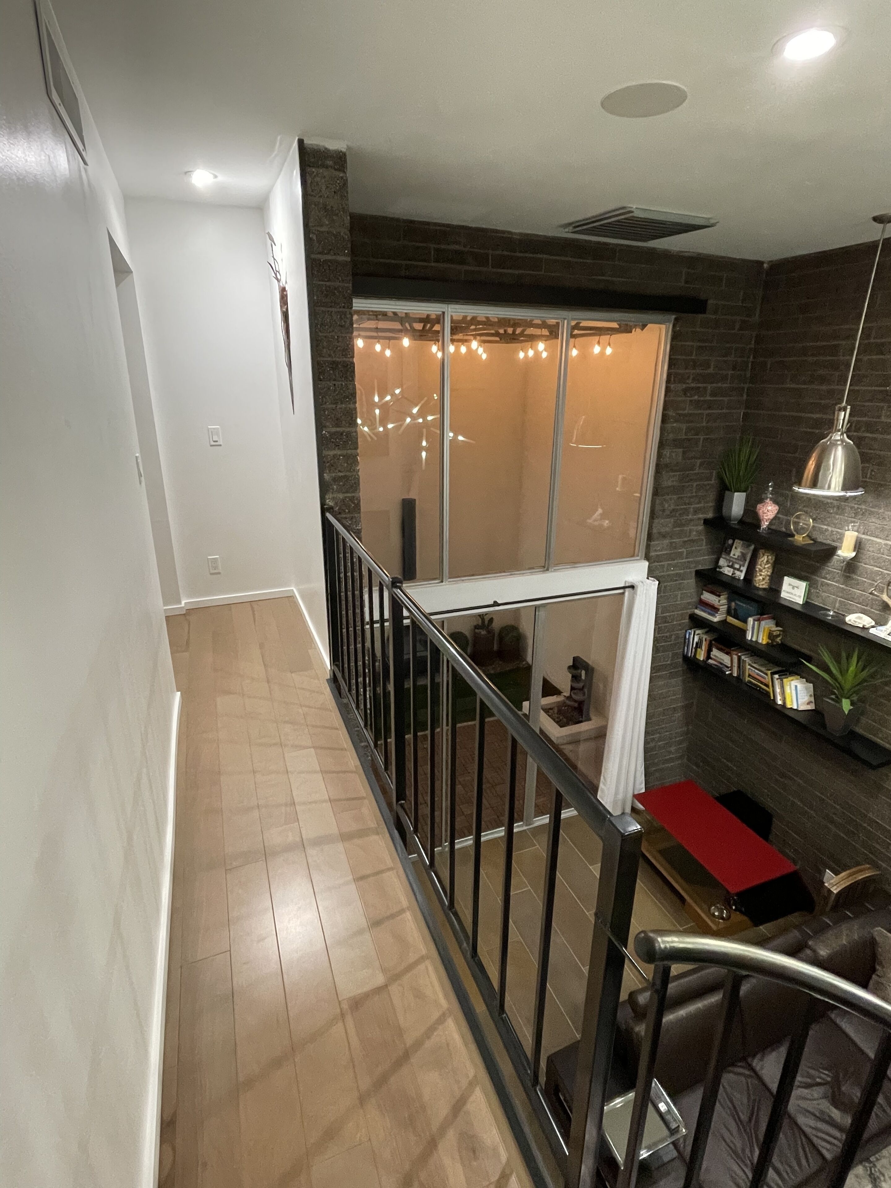 Un intérieur moderne avec un balcon, une cheminée et une bibliothèque.