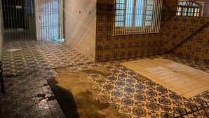 A room with patterned tile flooring, a barred window, and a door leading to an outdoor area. - Casa de Praia 80 Metros do mar (Itanhaém)