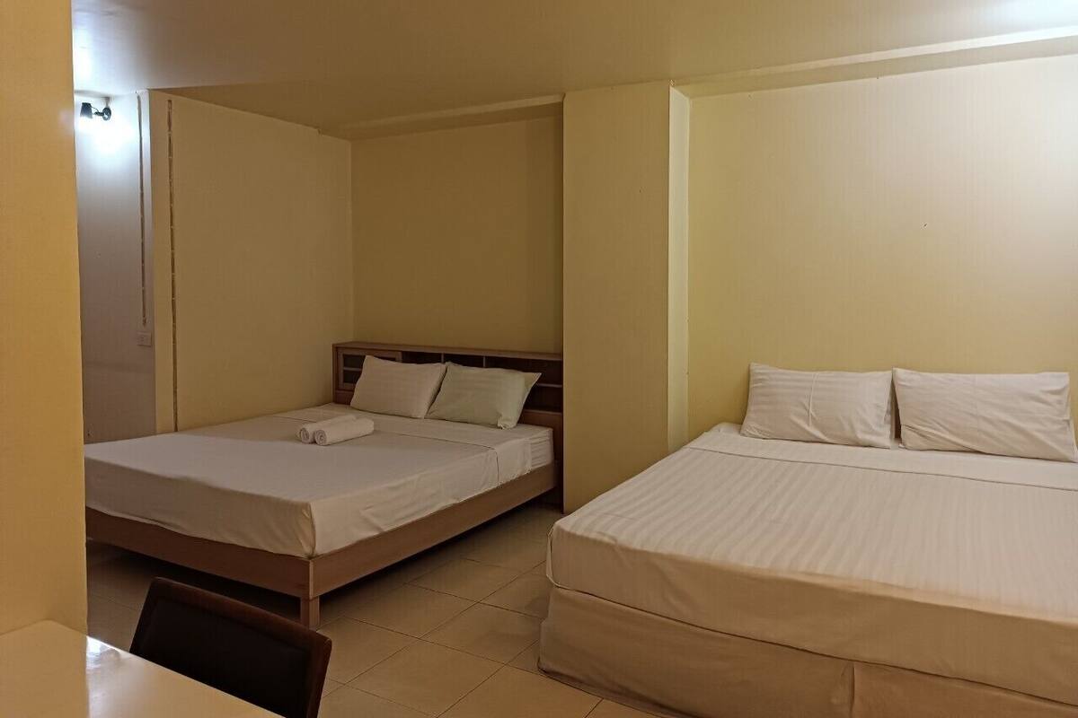 A room with two beds, a desk, and a chair.