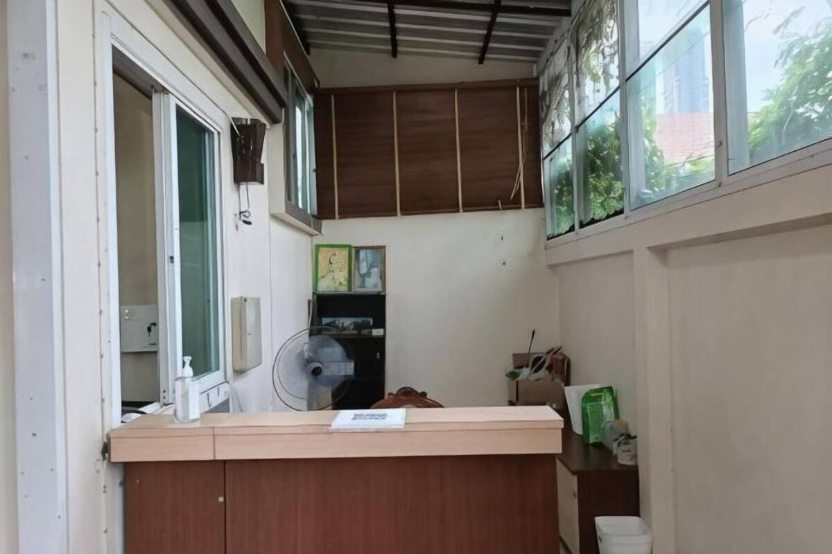 A narrow hallway with a wooden counter, a fan, a window, and a door.