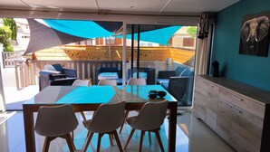 Una cocina moderna con comedor de vidrio, mobiliario de madera y vistas al patio exterior.