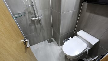 Un baño moderno con ducha, inodoro y estante de vidrio.