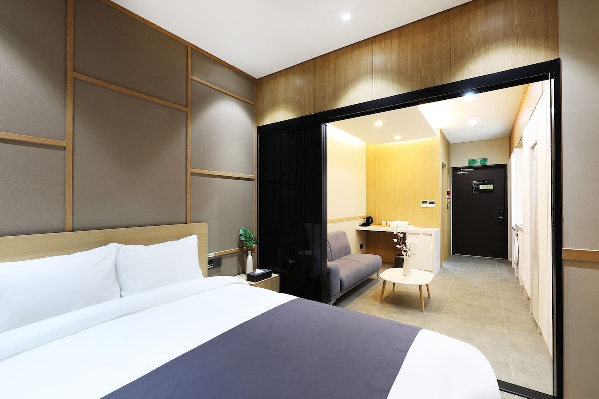 Een hotelkamer met een bed, een bureau, een stoel en een kast.