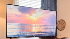 A flat-screen TV on a wooden entertainment center with a honeycomb design, a woven basket, and a box of Twister Connect Four. - Spring is Coming!  29 Miles to Nash, 1 Mile Downtown Gallatin (Gallatin)