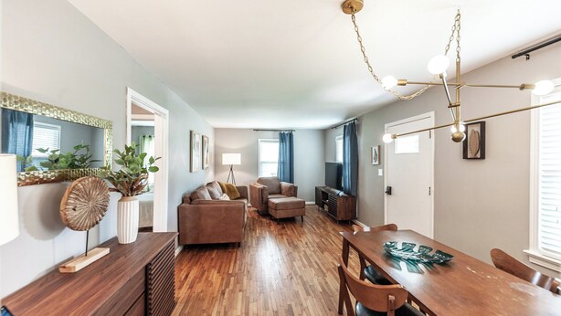 A modern living room with a wooden dining table, sofas, and a chandelier. - Spring is Coming!  29 Miles to Nash, 1 Mile Downtown Gallatin (Gallatin)
