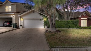A residential house with a garage, driveway, and a tree in the front yard. - The Cozy Houz at Cimarron! With Golf Course View (Mission)