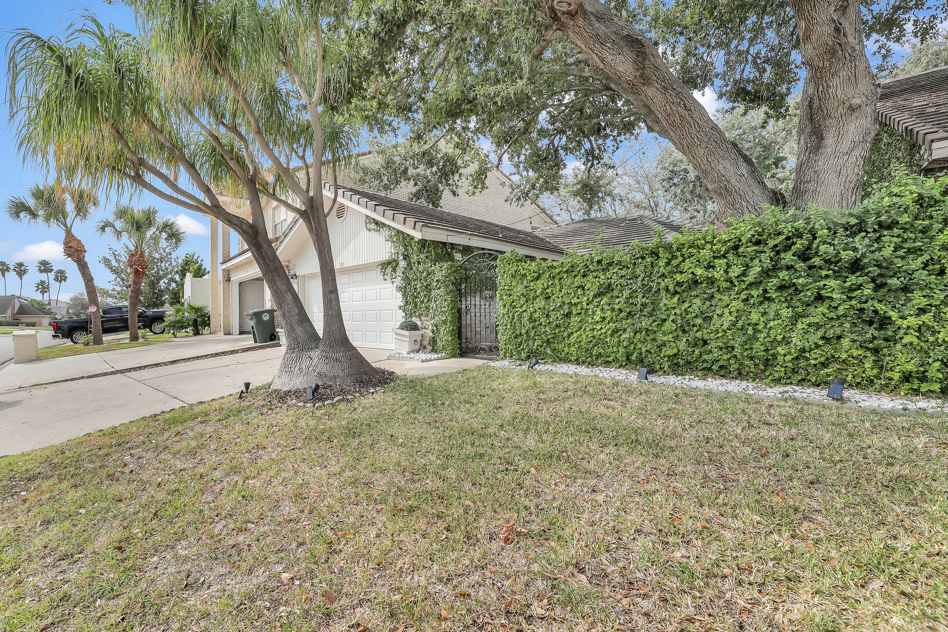 A residential area with a house, a driveway, and a well-maintained lawn.