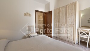 Een slaapkamer met een groot bed, een bureau en een kledingkast.