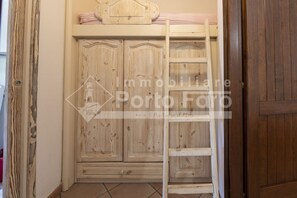 A wooden wardrobe with a ladder leaning against it.