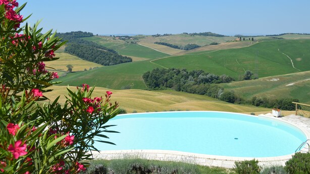 A pool with a view of rolling hills and a clear sky. - Apartment With Beautiful View in the Crete Senesi (Asciano)
