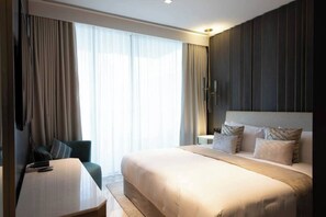 A hotel room with a large bed, a desk, a chair, and a TV. - Five Palm Jumeirah - 2 Bdr - Hotel Facilities Incl (Dubai)