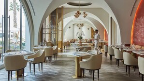 Un restaurant doté de hauts plafonds en arc de cercle, d’un mobilier moderne et offrant une vue sur l’extérieur.