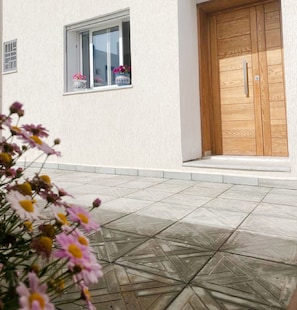 A building with a white exterior, a wooden door, and a window with a flower box. - Second Position Beach Dar Allouche Kélibia Rfi Rdc (Dar Allouche)