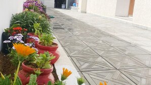 A tiled pathway with potted plants and flowers.