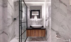 A modern bathroom with a marble wall, a wooden vanity, a glass shower enclosure, and a built-in mirror. - Room-luxury Triple Room in Istanbul (Istanbul)