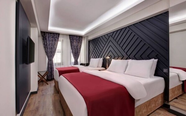 Relax in a stylish room with a large bed, flat-screen TV, and geometric-patterned headboard.
