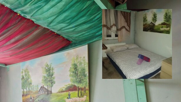 Ein Zimmer mit einem Bett, einem Landschaftsbild und einem Stockbett.
