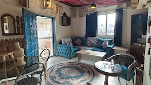 A cozy living room with a blue sofa, a coffee table, and a patterned rug.