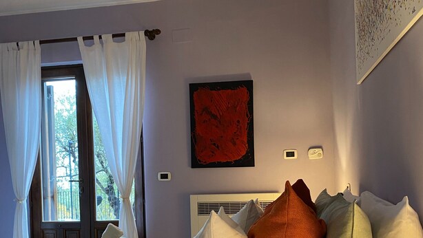 A hotel room with a bed, pillows, a lamp, and a window with curtains. - Magnificent Villa Between Etna and the sea With Breathtaking Views of Mount Etna (Linguaglossa)