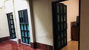 A corridor with tiled flooring, a door with a metal grid, and a wall with a small shelf. - Department, Studio Type Excellent Location (Mexico City)