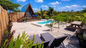 A wooden A-frame structure with a pool, lounge chairs, and a bamboo fence. - Cashaw Cabin - Private Retreat With a Pool (Treasure Beach)