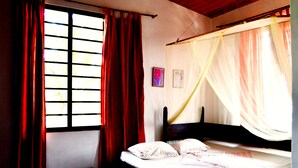 A bedroom with a bed, a window with curtains, and a mosquito net. - Beach Villa Yang Near Hikkaduwa, With Pool and Cook - Semi-detached House (Hikkaduwa)