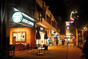 A nighttime street scene with a Starbucks Coffee shop, outdoor seating, and a Beer Garden. - B201 - 1 Bedroom Condo With Sea View, Ao Nang Beach (Krabi)