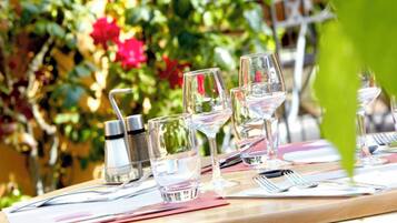 A table set outdoors with wine glasses, cutlery, and condiments.