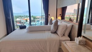 A hotel room with a large bed, a view of the city, and a window with curtains. - Bo401 - 2 Bdr Condo With Sea View, Ao Nang Beach (Krabi)
