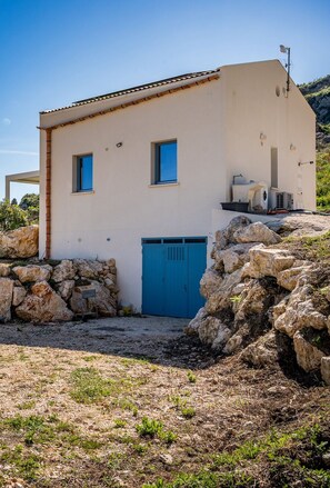 Un edificio con una porta blu, una piccola finestra e un'antenna parabolica sul tetto.