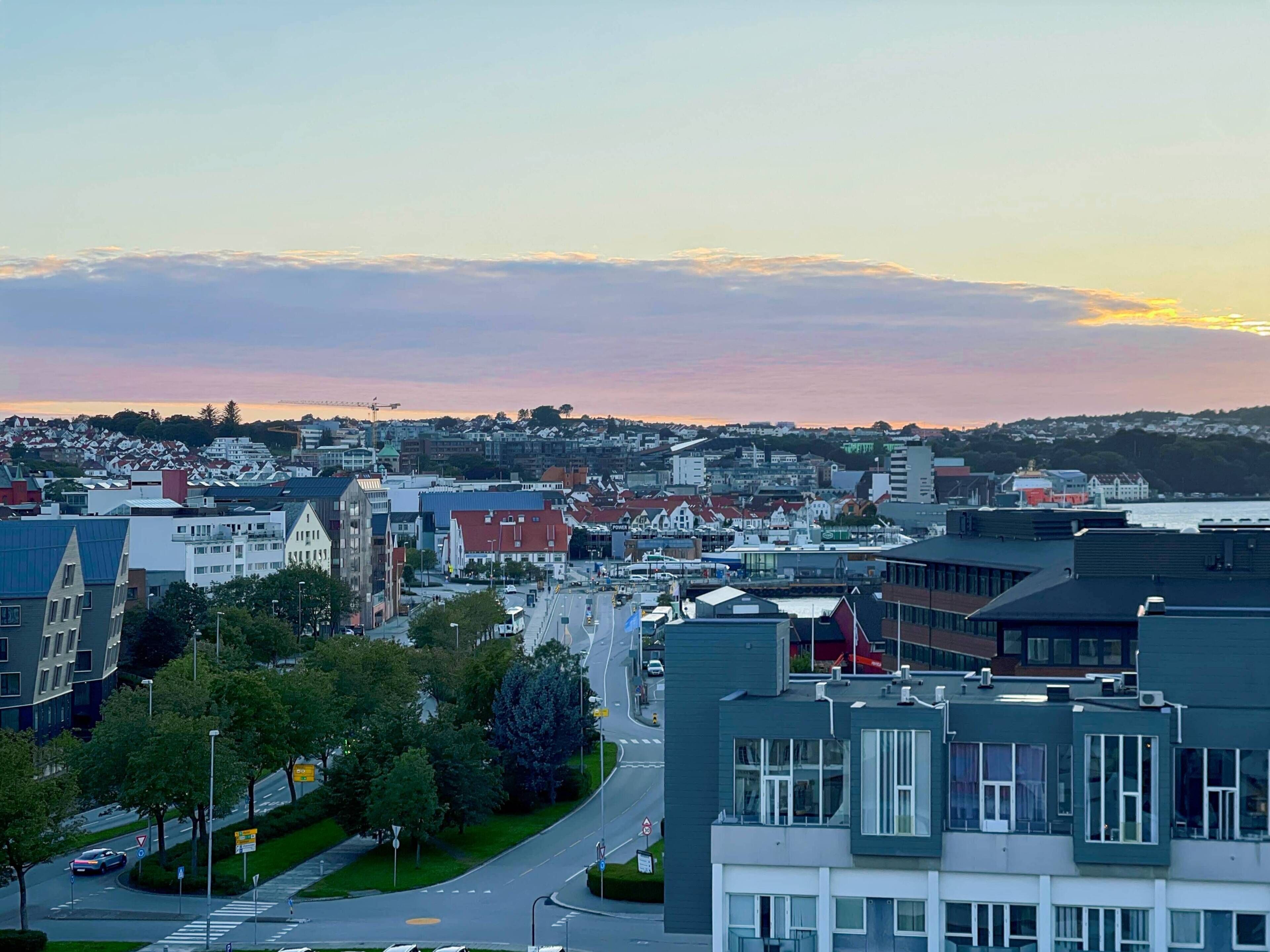 Un horizonte urbano con edificios modernos, cielo despejado y un atardecer.