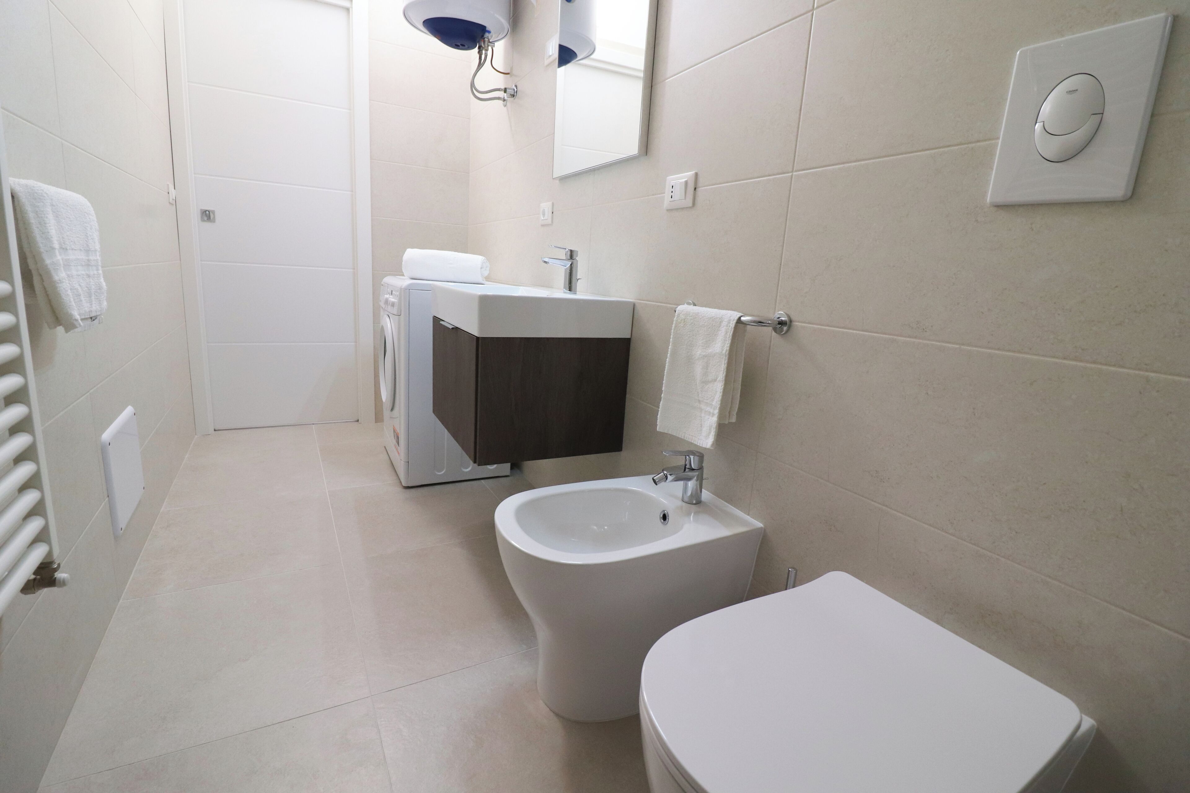 A modern bathroom with a toilet, bidet, and sink.