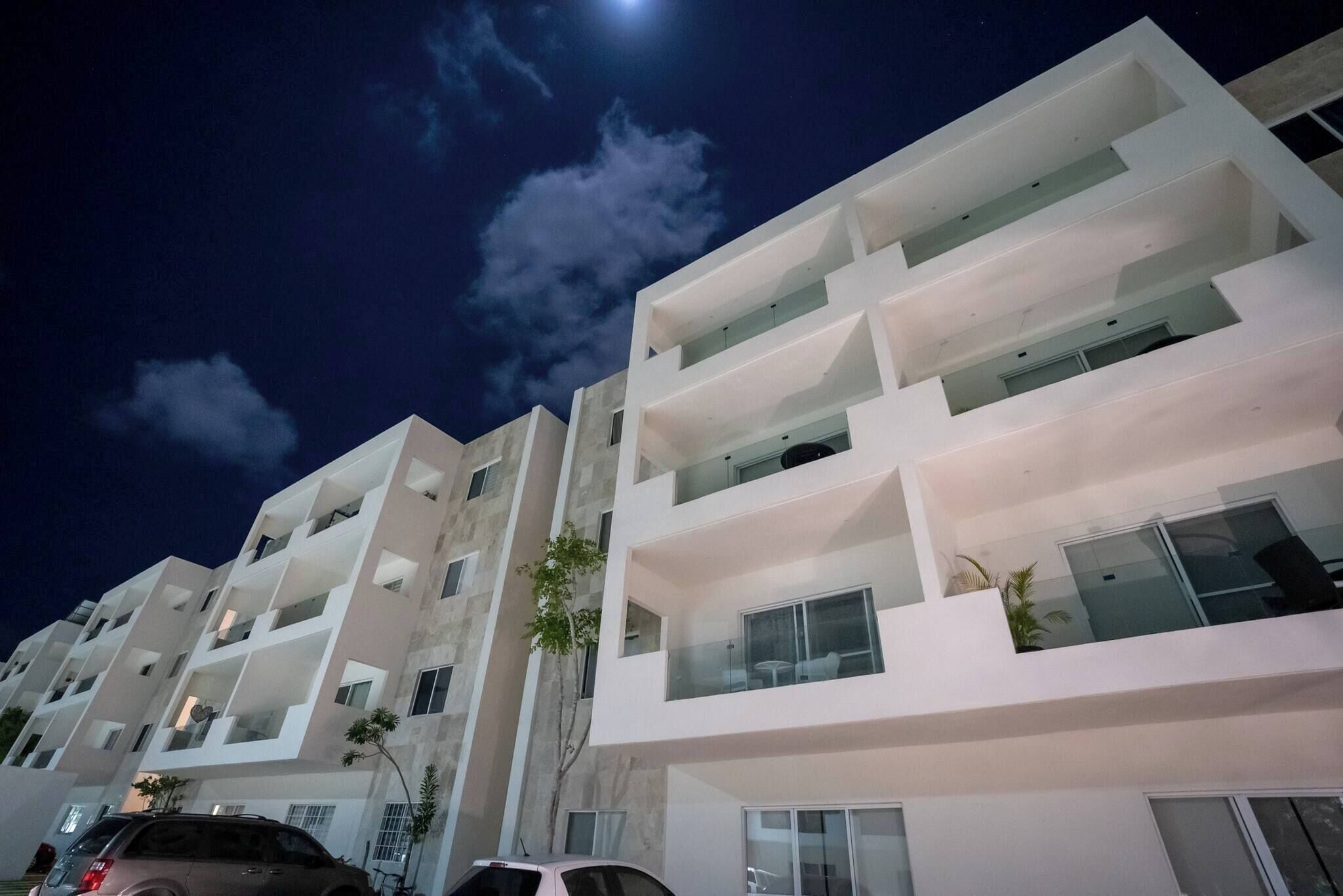 A multi-story building with balconies and large windows.