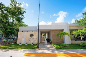 Un bâtiment moderne doté d’un espace d’accueil, d’une enseigne indiquant « Casa Club Grupo Veleas » et d’un chemin menant à l’entrée.