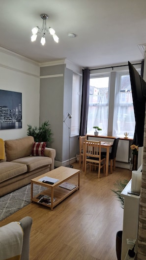 Un salon comprenant un canapé, une table basse et un coin repas avec une table et des chaises.
