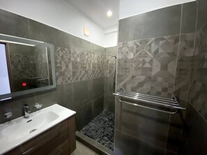 A modern bathroom with a large mirror, a sink, and a shower area. - Magnifique Villa Avec Piscine (Grand-Baie)