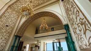 A grand lobby with ornate gold detailing, a chandelier, and a reception desk. - DAYAL GATEWAY (Lucknow)