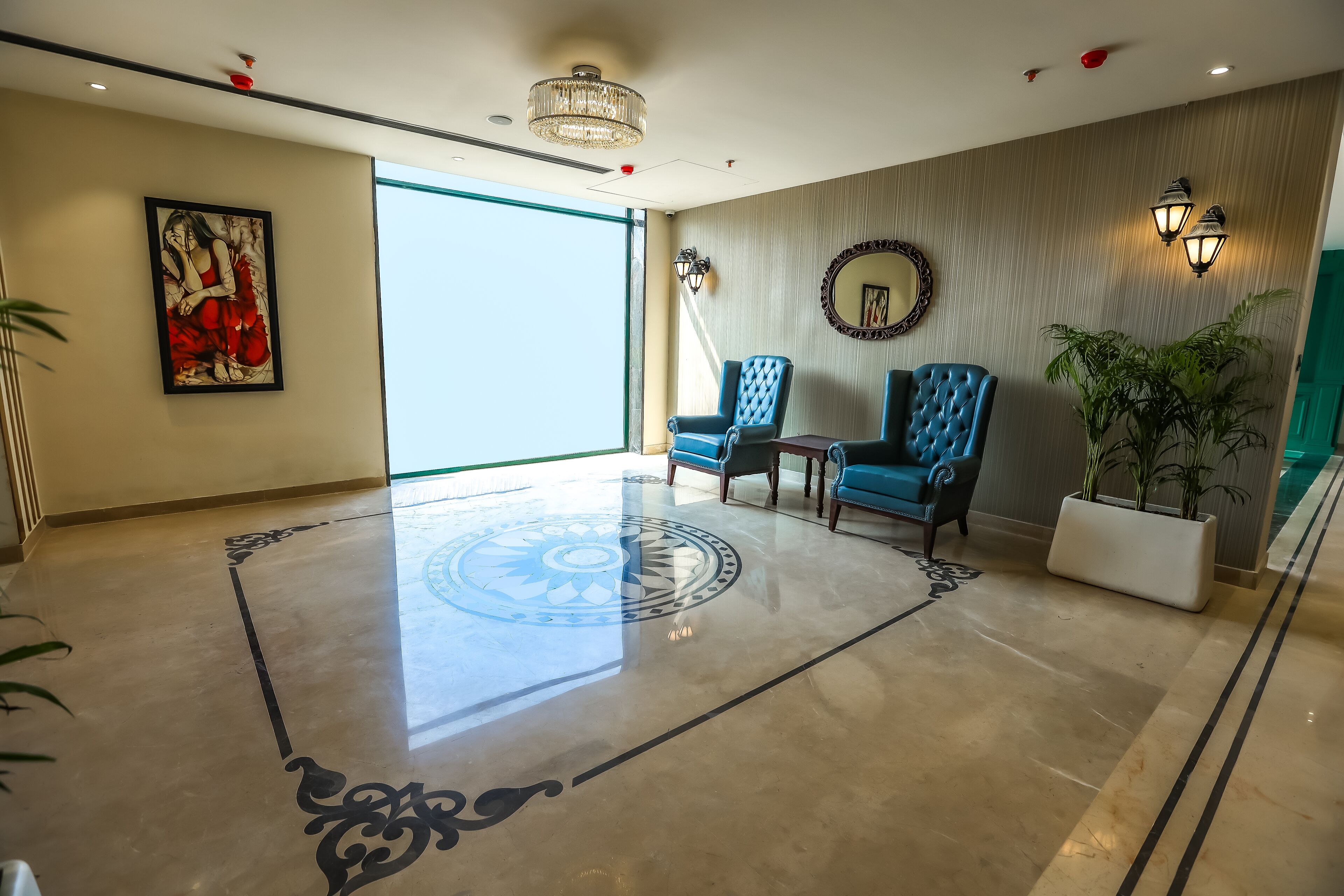 A spacious lobby with a polished marble floor, a large window, and a chandelier.