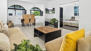 Una sala moderna con sofá, mesa de centro y comedor con sillas.